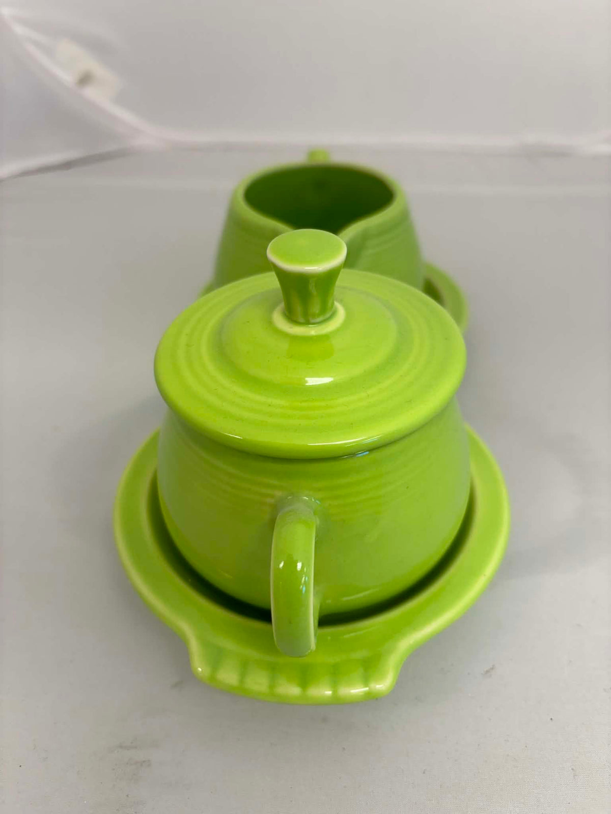 This is a Fiesta Fiestaware Creamer Pitcher Sugar Bowl with Lid on Figure Eight 8 Tray Set in chartreuse lead-free, Post 1986, Retired Color Retired Shape

