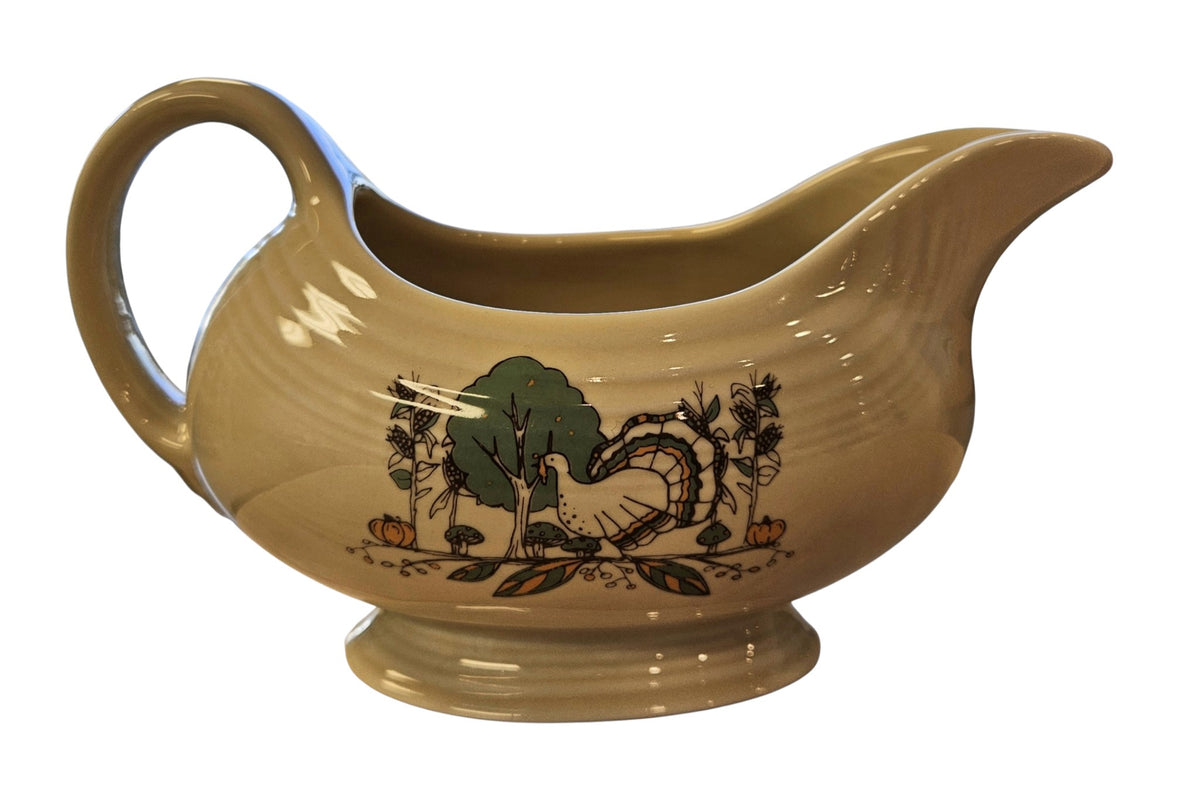 This is a Fiesta fiestaware Sauce Gravy Boat featuring Everything Kitchen's Fall Forest decal on Ivory. Lead free, Post 1986 Retired Decal, Retired Color, limited quantities available via EK, Fall, Greenery, Cabin, Bird, Turkey, Tree, Thanksgiving
