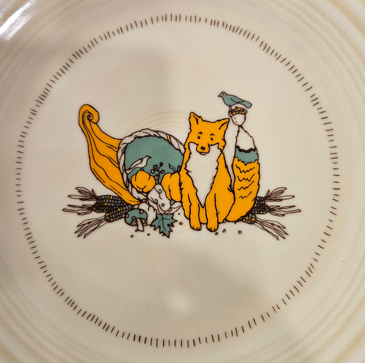 This is a Fiesta fiestaware Classic Salad Plate featuring Everything Kitchen's Fall Forest decal on Ivory. Lead free, Post 1986 Retired Decal, Retired Color, limited quantities available via EK, Fall, Pumpkin, Greenery, Bird. Acorn, cornucopia, fox, Thanksgiving
