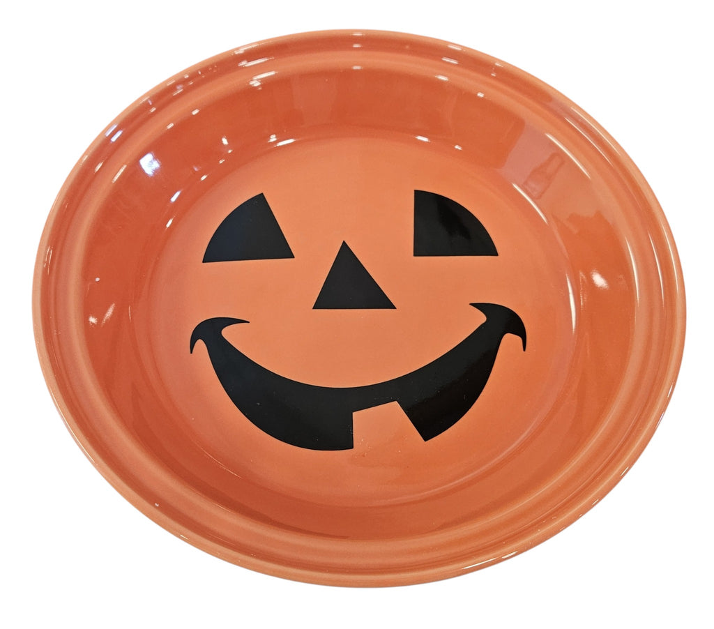 This is a Fiesta fiestaware Large Pie Baker featuring the Happy Pumpkin decal on persimmon. Lead free, Post 1986, Retired Production Decal, Retired Color, Fall, Thanksgiving, Halloween
