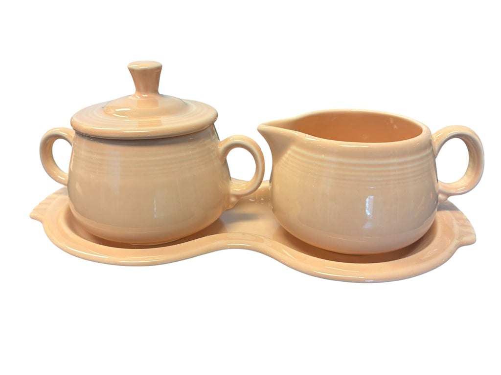 This is a Fiesta Fiestaware Creamer Pitcher Sugar Bowl with Lid on Figure Eight 8 Tray Set in apricot lead-free, Post 1986, Retired Color Retired Shape
