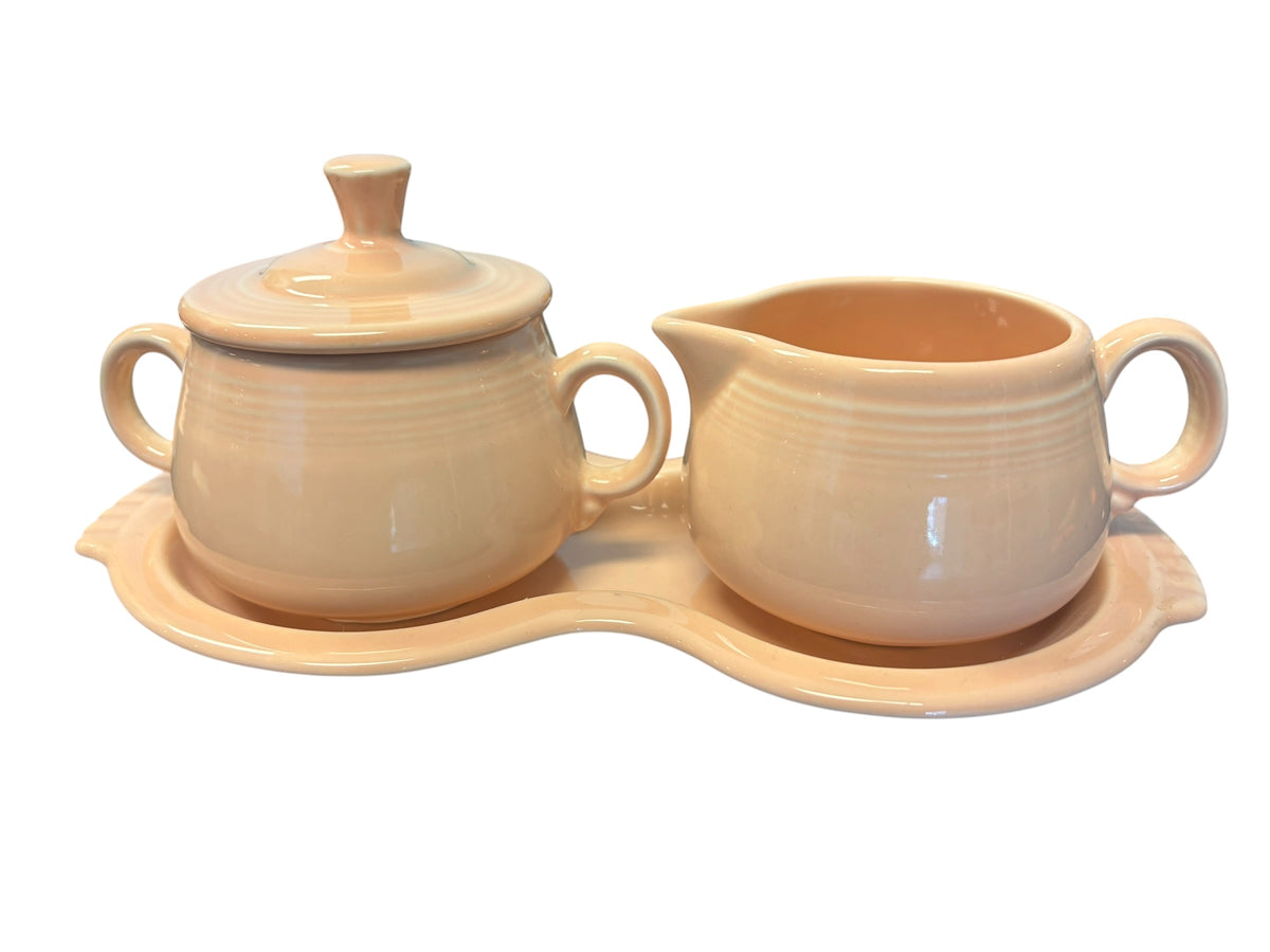 This is a Fiesta Fiestaware Creamer Pitcher Sugar Bowl with Lid on Figure Eight 8 Tray Set in apricot lead-free, Post 1986, Retired Color Retired Shape
