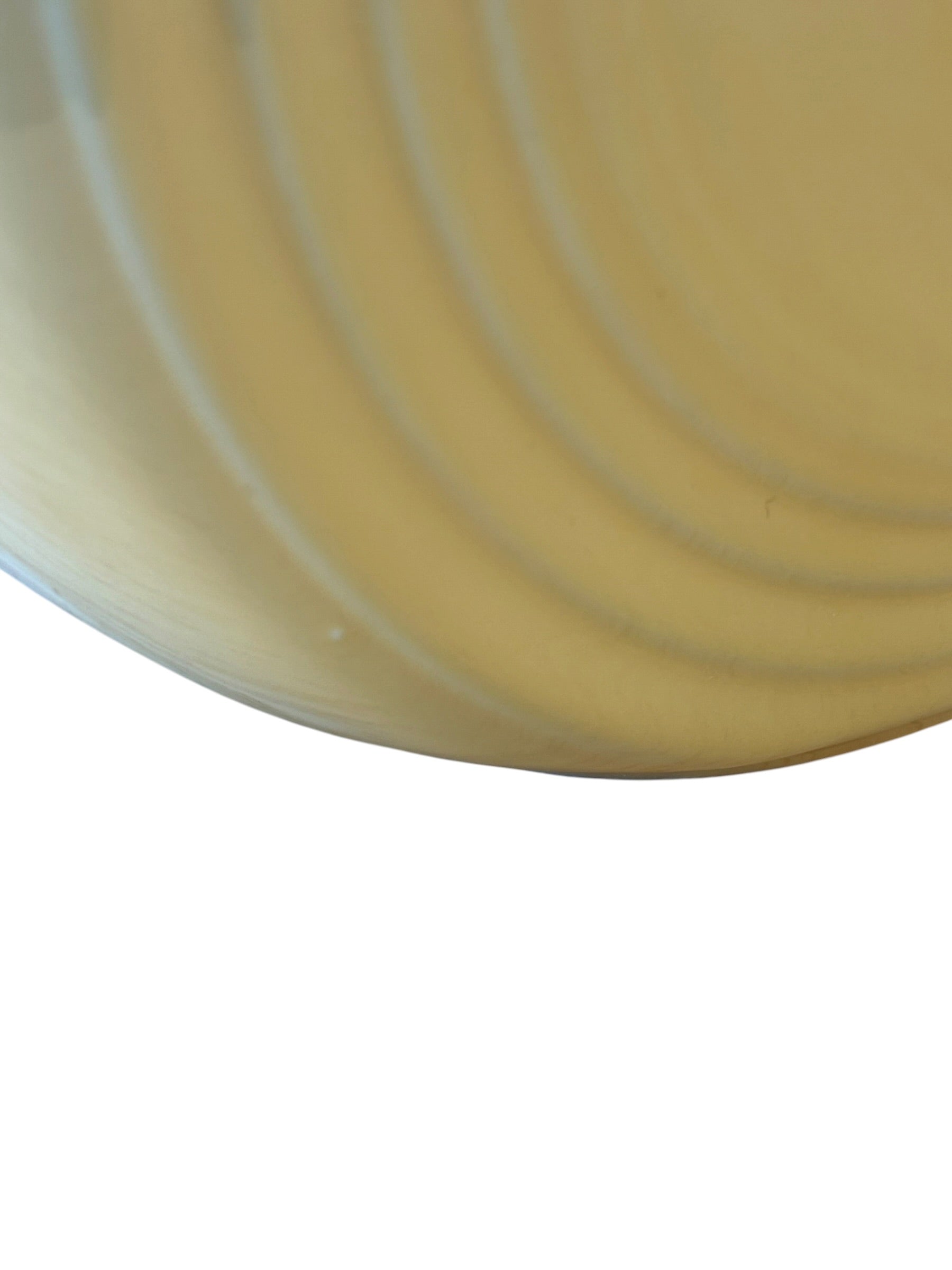 A close-up of a pale yellow-beige curved surface with concentric circular ridges, shown against a white background. Fiesta Millennium II Vase Yellow Sand Bump